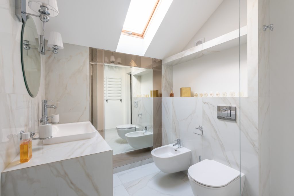 Clean bathroom with sink, shower, toilet, and a freestanding bidet.