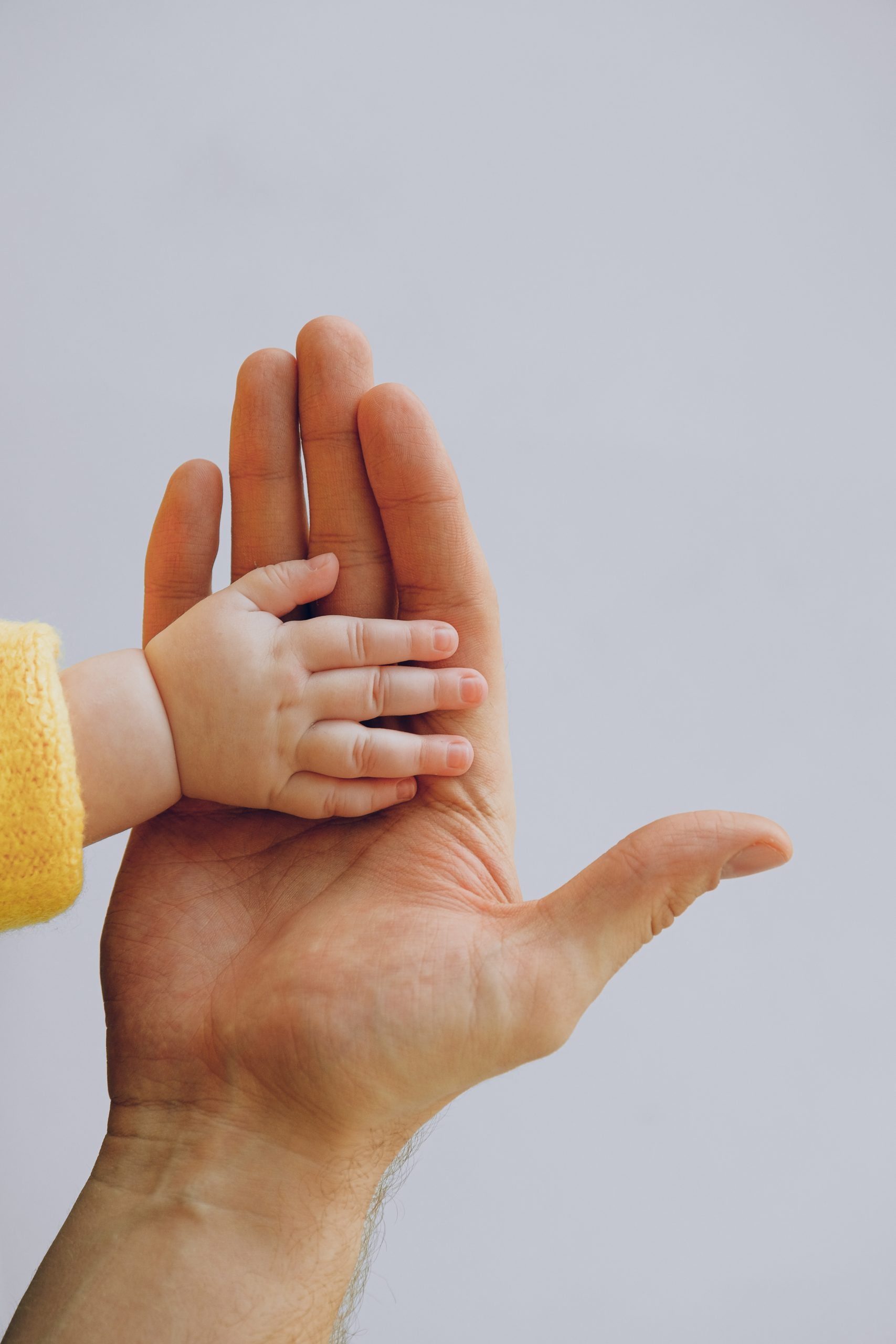 Baby's hand in baba's.
